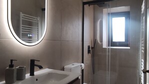 A modern bathroom with a large mirror, a sink, a toilet, and a shower area. - Room in Ponte da Barca (Vila Nova de Muía)