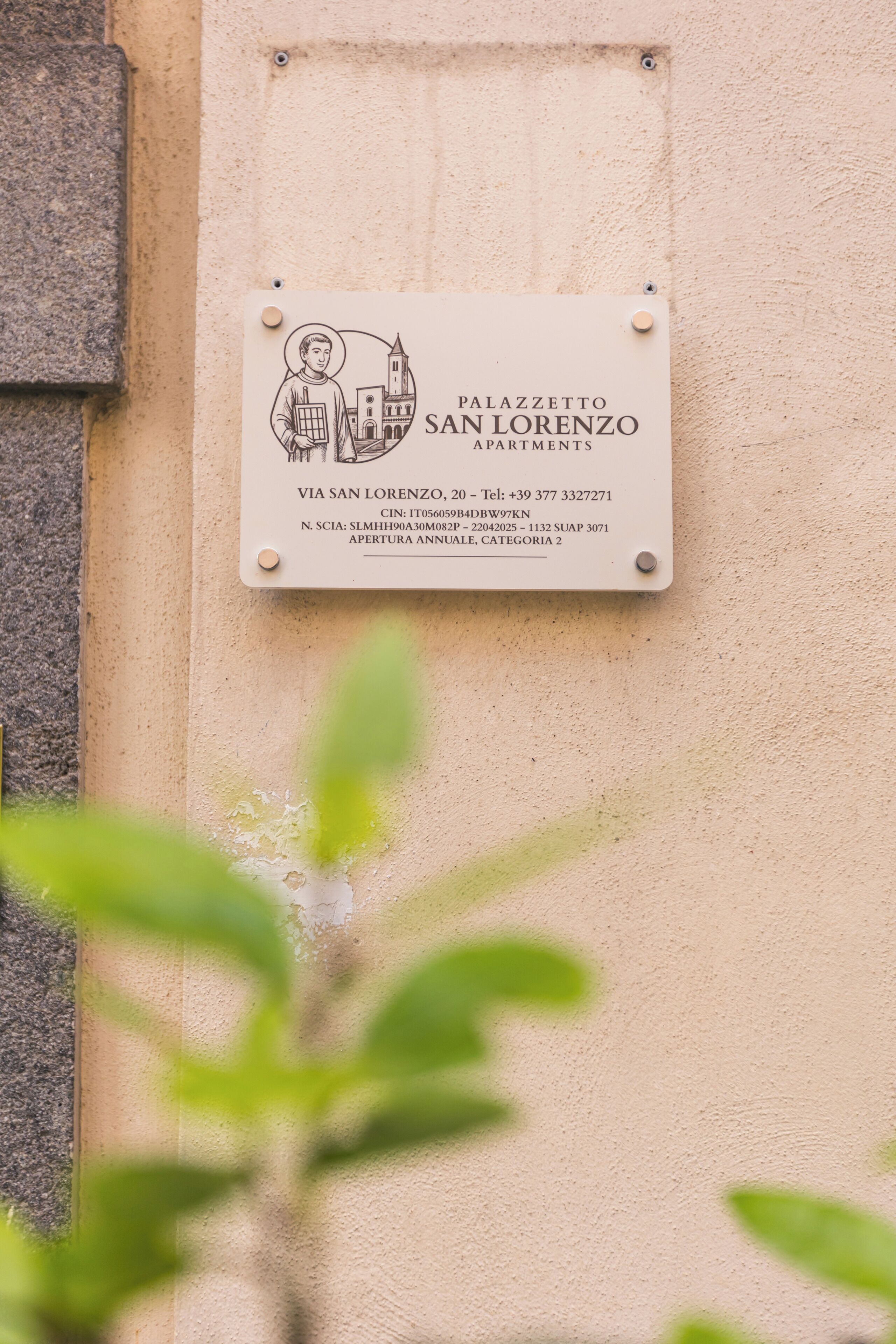 A sign for Palazzo San Lorenzo Apartments with contact details and address.