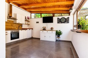 Eine moderne Küche mit weißen Schränken, einem eingebauten Backofen und einer Holzziel.