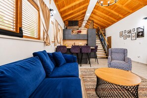 A modern living room with a blue sofa, a round coffee table, and a patterned rug. - Villa Ika - Two Bedroom Villa, Sleeps 4 (Raštević)