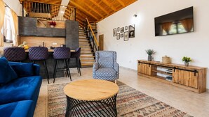 Ein stilvolles Wohnzimmer mit einem blauen Sofa, einem runden Holztisch und einem gemusterten Teppich.