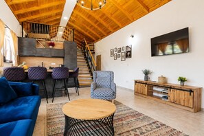 Ein stilvolles Wohnzimmer mit einem blauen Sofa, einem runden Holztisch und einem gemusterten Teppich.