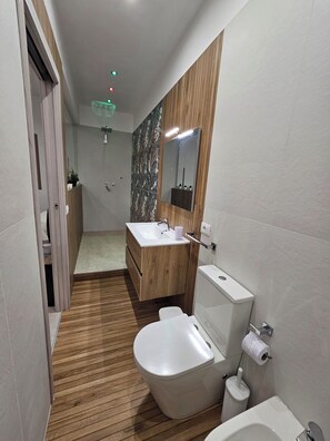 Ein modernes Badezimmer mit einem Holzlagerfläschchen, einer Toilette und einer Duschkabine.