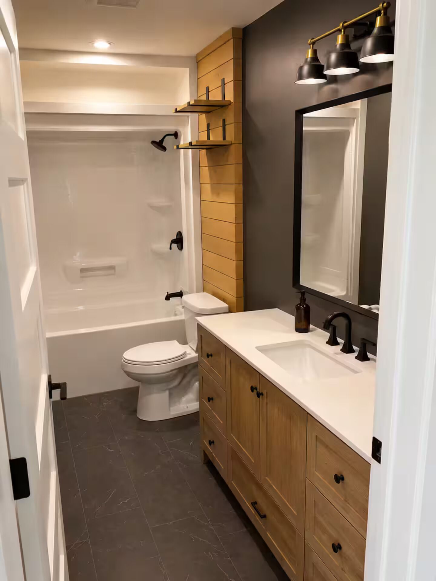 Une salle de bain moderne équipée d’une baignoire, de toilettes et d’un meuble-lavabo avec un miroir.