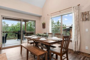 Un comedor con una mesa de madera dispuesta para cuatro personas, bancos y sillas.