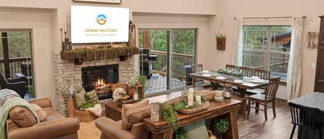 A cozy living room with a fireplace, comfortable seating, and a dining area.