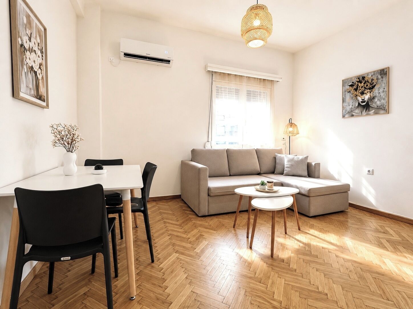 Un salon moderne comprenant un canapé, une table à manger avec des chaises, une petite table basse et un luminaire suspendu.
