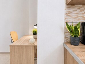 A wooden dining table with a chair, a potted plant, and a lamp. - Athens Base Αpt - Near Metro & Museum by ΜΡS (Athina)