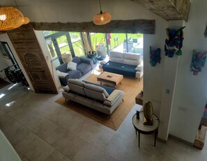 A spacious living area with a sofa set, a coffee table, and a hanging light fixture. - Mas La Fontaine de Pernes, right on the banks of the Sorgue River, with a pool, sleeps 12, 6 bedrooms, 5 bathrooms (Pernes-les-Fontaines)