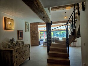 A staircase with a wooden finish and black railings leading to an upper floor.