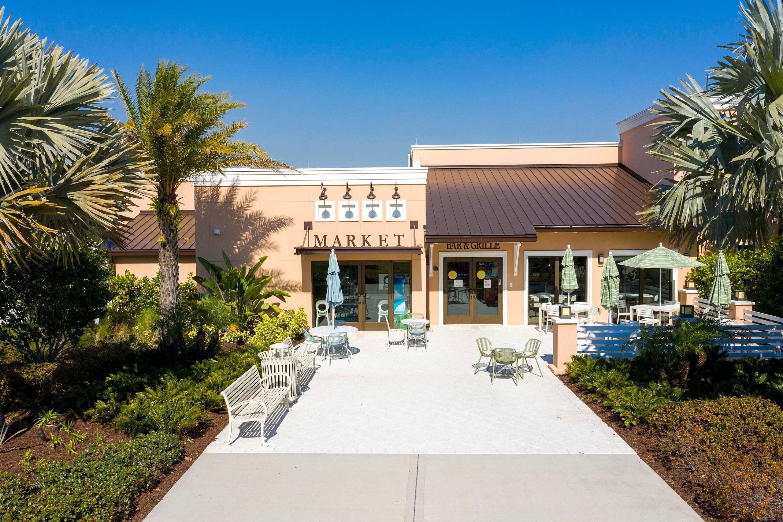 A building with a 'MARKET' sign, outdoor seating, and a 'BAR & GRILLE' sign.