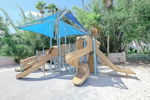 A playground with slides and a shaded area. - Orlando | Park Trip Base Stay | Pool + Golf (Lake Buena Vista)