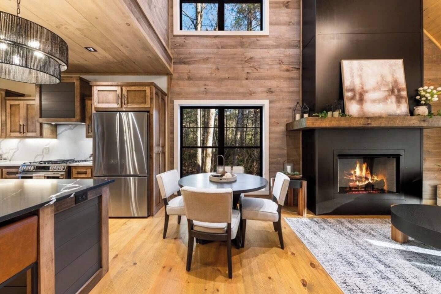 A modern kitchen with a large island, stainless steel appliances, and a dining area with a round table and chairs.