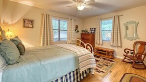 A bedroom with a bed, a dresser, a chair, a ceiling fan, and a window with curtains. - Bear Ridge-Private Cabin-Mountain Views-Hot Tub! (Blairsville)