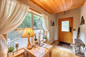 A wooden interior with a table, lamp, and window with curtains. - Bear Ridge-Private Cabin-Mountain Views-Hot Tub! (Blairsville)