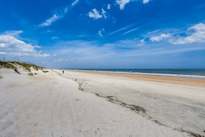 Ein Strand mit klarem Himmel und sandigem Ufer.