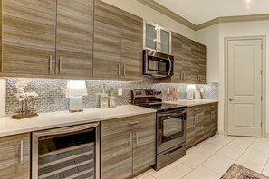 A modern kitchen with built-in appliances, a microwave, and a stove. - Amelia Island Luxury Summerwoods Condo near Ritz Carlton / Omni (Fernandina Beach)