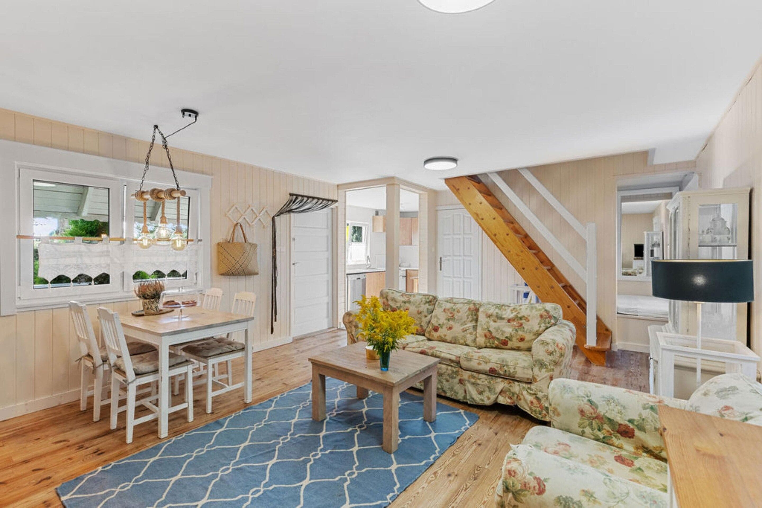A spacious living area with a dining table, chairs, a sofa, and a coffee table.