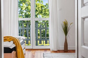 A room with a bed, a window with a view of trees, and a potted plant. - Large and Comfortable Holiday Home With a Terrace (Darlowo)