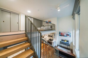 Ein modernes Interieur mit einer Holztreppe, einer Küchenzeile und einem Essbereich.