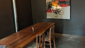 A dining area with a wooden table, two chairs, and a single candle. - Two bedroom underground space sits right on the water. (Eclectic)