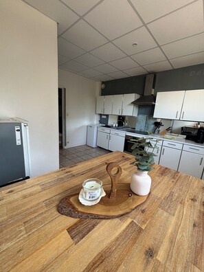 A modern kitchen with white cabinets, a wooden countertop, and a potted plant. - Exceptional view - Centre Pont d'Ouilly (Pont-d'Ouilly)