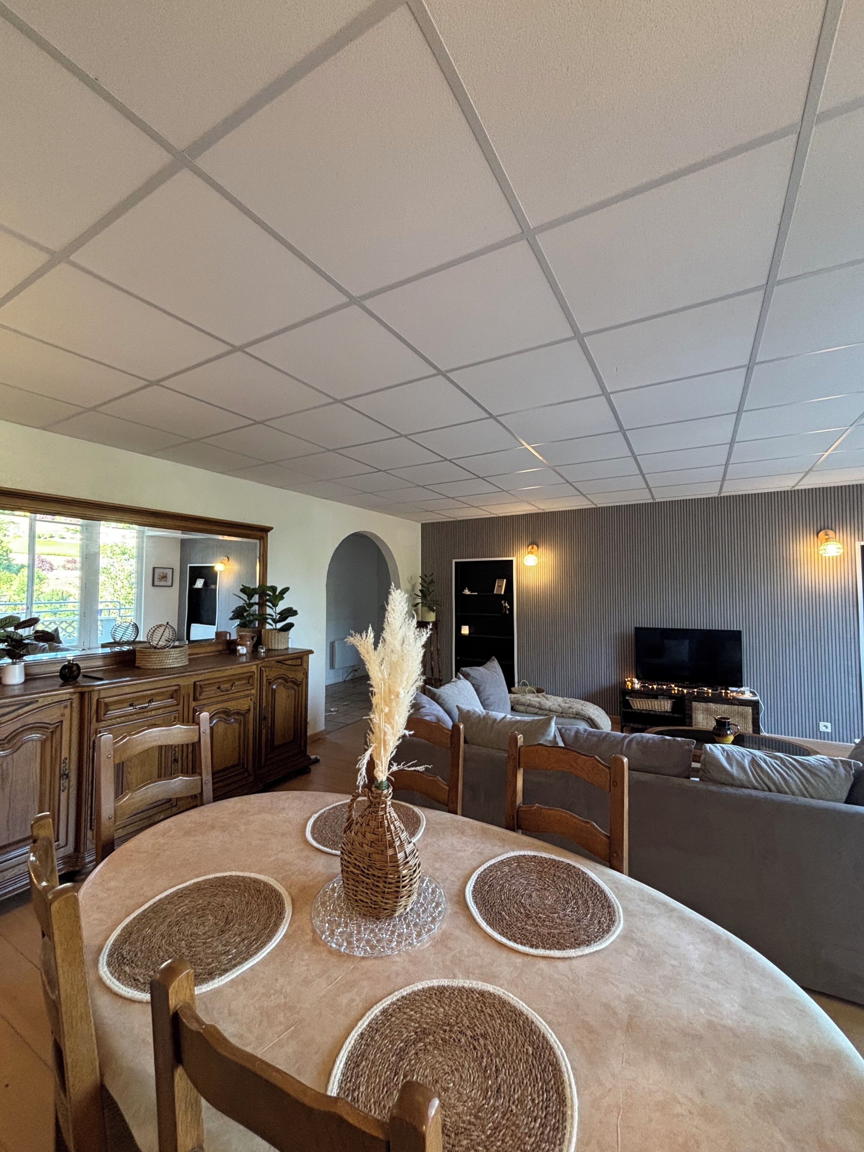 A spacious living area with a dining table, chairs, a sofa, and a television.