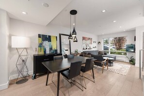 A modern living space with a dining area, seating, and a TV.