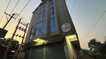 Un edificio con un cartel que indica la clínica de extensión KGMT y un cartel para servicios sanitarios.