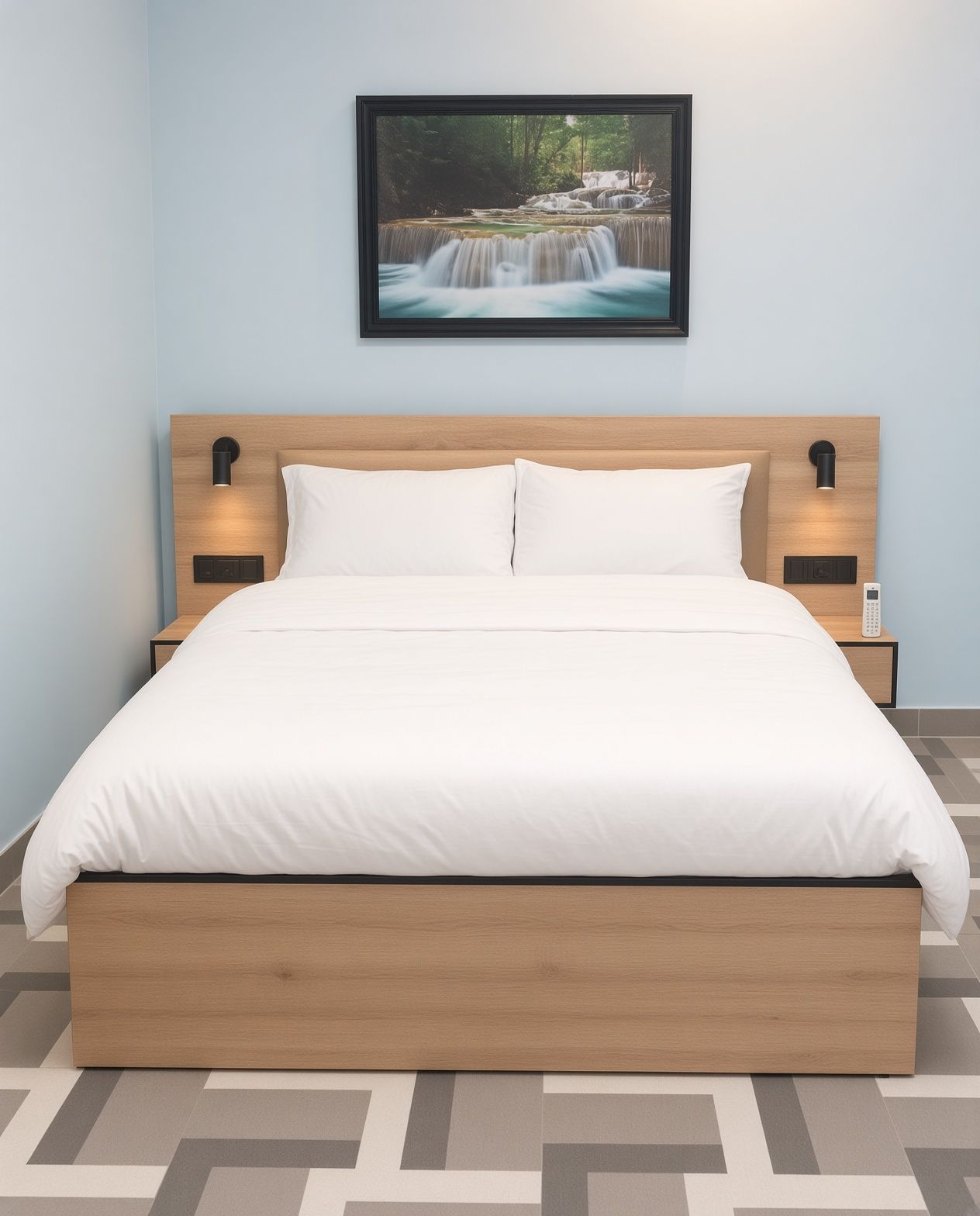 Een net opgemaakt bed met een houten hoofdbord, twee nachtkastjes met lampen, en een lijst met een foto van een waterval aan de muur.