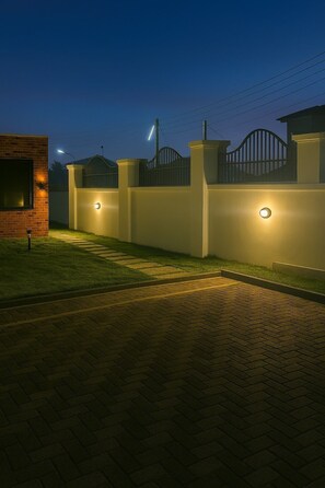 A gated residential area with a brick building and a paved driveway at dusk. - Zenith House Two ~refined, fully serviced accommodation (Ibadan)