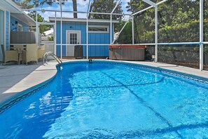 A swimming pool with a covered area, a door, and a small building with a window. - Blue Chip Escape-Private Pool-30A-Bikes (Santa Rosa Beach)