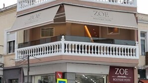 Un hotel boutique de dos pisos con un balcón en el nivel superior.