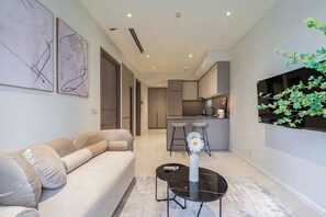 A modern living room with a sofa, a coffee table, and abstract wall art. - The Opera D2 Apartment  (Ho Chi Minh City)