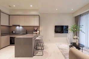 Una cocina moderna con una isla central, taburetes de bar y un comedor con mesa y sillas.