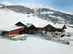 A snow-covered mountain resort with wooden buildings and a ski slope. - Panoramic View Apartment Kaunergrat (Kaunerberg)
