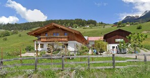 A wooden chalet with a balcony, surrounded by a wooden fence, set in a mountainous area with a clear sky. - Panoramic View Apartment Kaunergrat (Kaunerberg)