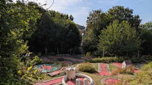 En anlagt have med stier, et lille tårn og mange forskellige planter.