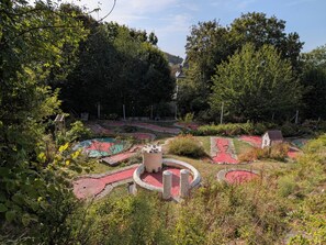 Ein angelegter Garten mit Wegen, einem kleinen Turm und verschiedenen Pflanzen.