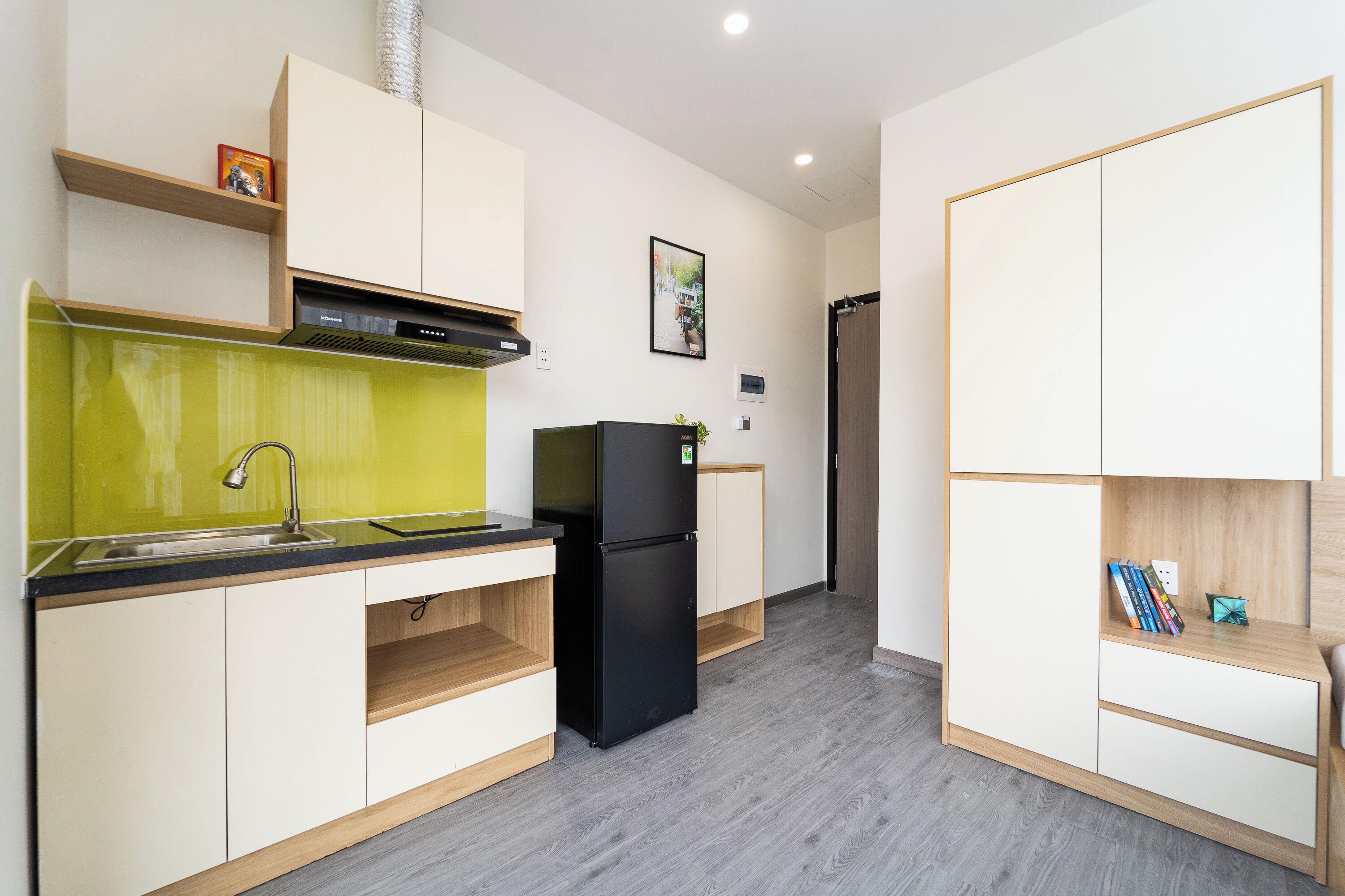 A compact kitchen with a sink, a black refrigerator, and a small countertop.