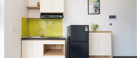 A compact kitchen with a sink, a black refrigerator, and a small countertop.