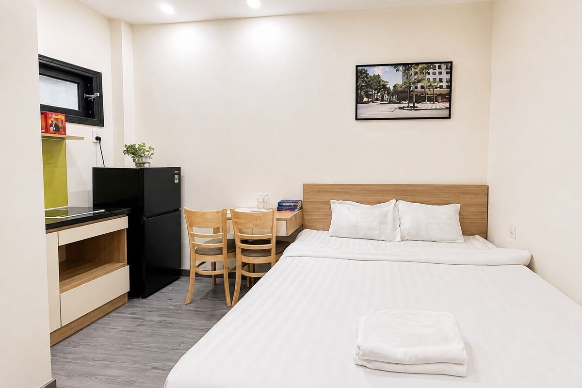 A hotel room with a bed, a desk, and a chair.