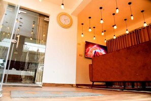 A modern living room with a sofa, a television, and pendant lighting. - Lovely Homestay  (Ella)