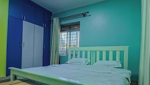 Ein Zimmer mit einem Bett, einer Sitzbank und einem Kleiderschrank.