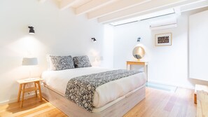 A modern bedroom with a large bed, bedside lamps, a small table, and a wall-mounted mirror. - Unique Beachside Triplex by LovelyStay (Matosinhos)