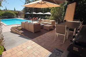 A backyard with a swimming pool, outdoor furniture, and a grill area. - Air-Conditioned Provençal Villa with Pool - Large Terrace and Quiet Garden (Draguignan)