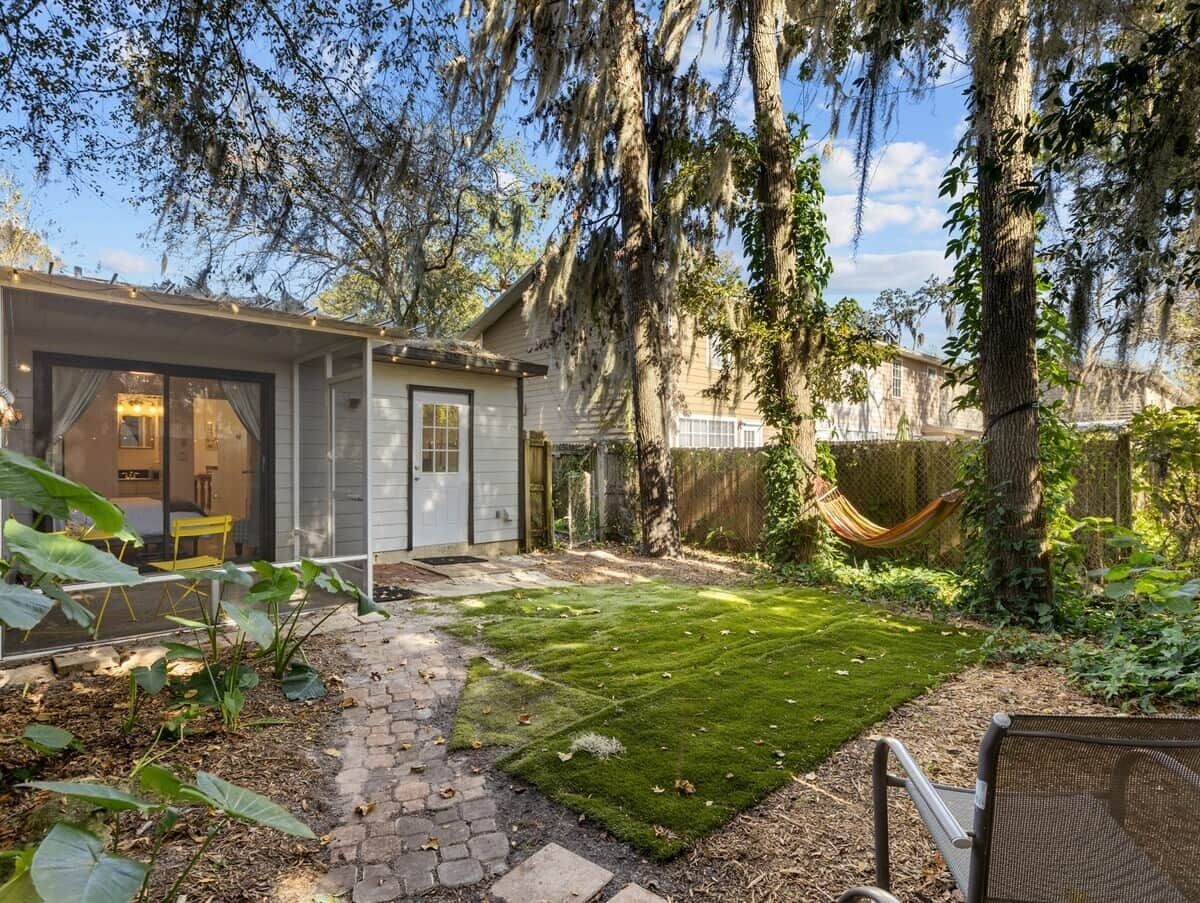A residential property with a paved patio, a hammock, and a well-maintained lawn.