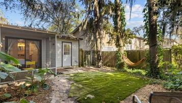 A residential property with a paved patio, a hammock, and a well-maintained lawn.