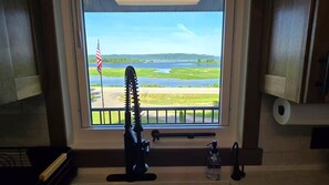 A kitchen with a window view of a lake and a flag. - Mississippi River view. Duck Hunters Get away. 4 Bedroom, 5 bed - Sleeps 10. (Brownsville)