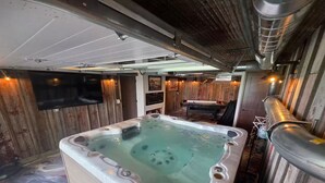 Ett bubbelbad i ett rum med väggar av trä och ett tak med synliga ventilationskanaler.